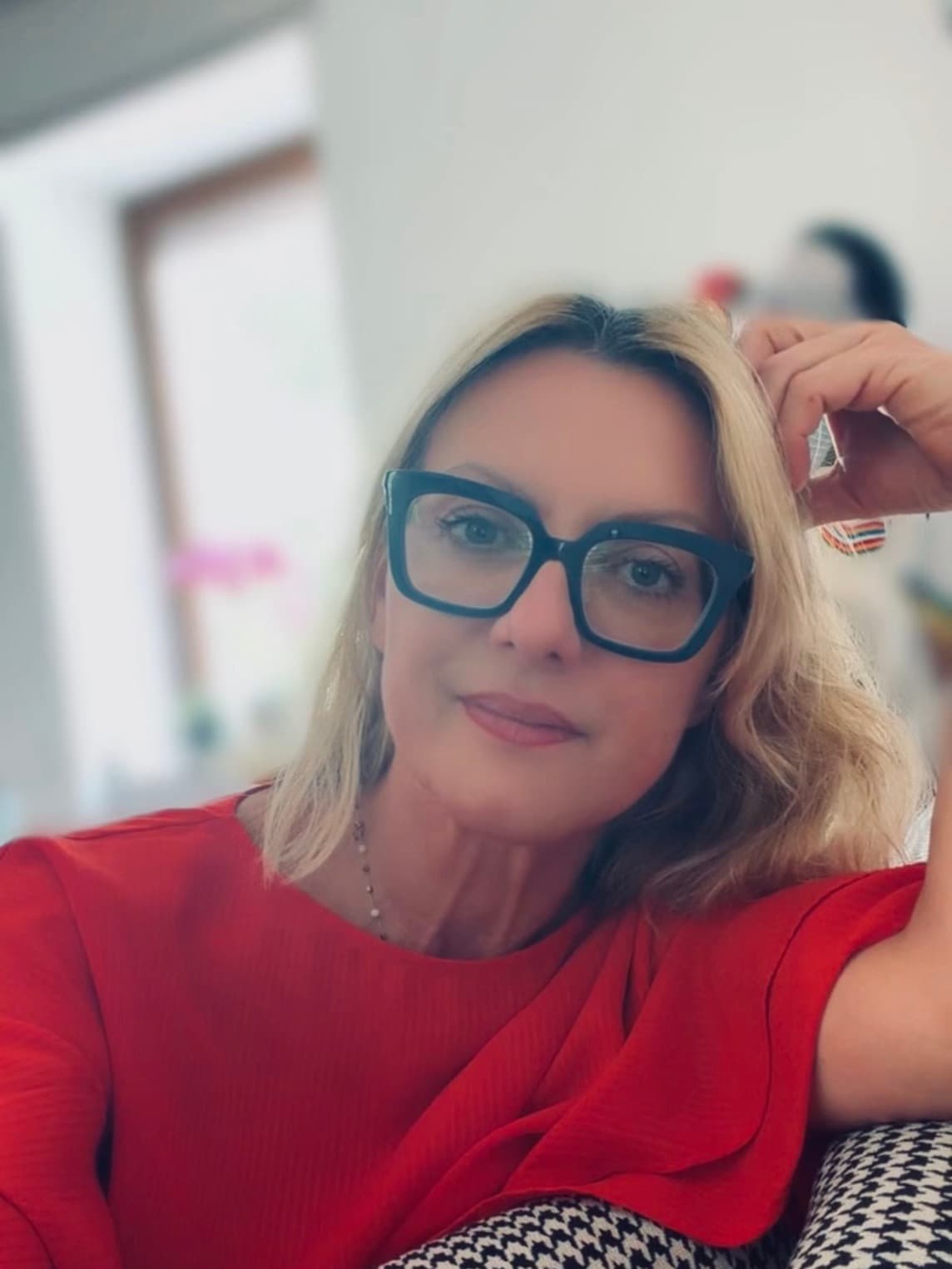 Ritratto di Sabrina Prioli con gli occhiali, seduta in poltrona
